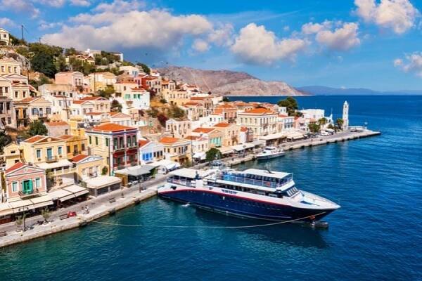 Pohled na přístav ostrova Symi (Simi), klasické jachty, domy na ostrovních kopcích, Egejský záliv. Řecko ostrovy dovolená dovolená cestování zájezdy z ostrova Rhodos. Symi, Greece, Dodecanese. — Stock obrázek