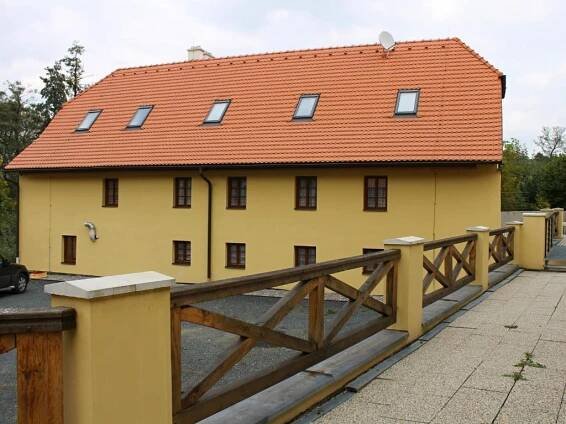 a yellow building with a red roof and a wooden fence at Žabonosy Mlýn in Žabonosy