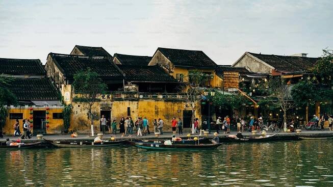 a group of people standing on a pier next to a body of water