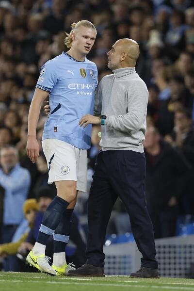 Erling Haaland of Manchester City talking to manager Pep Guardiola after being substituted.