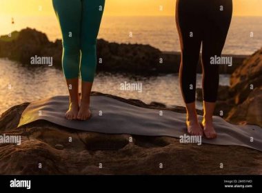 Legs of two women doing meditation and yoga exercises in nature by the sea at sunset, healthy and naturist life, outdoor pilates Stock Photo - Alamy