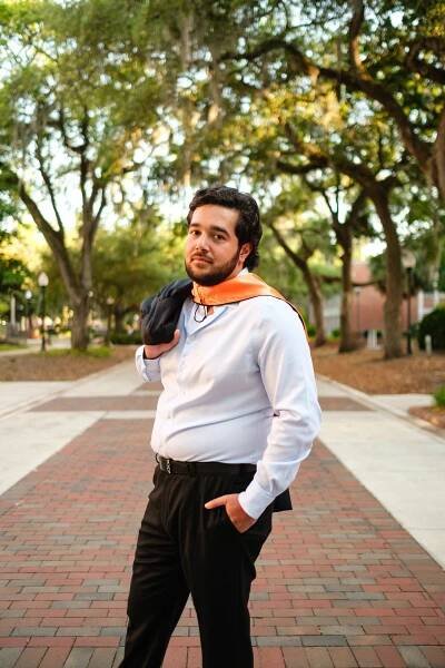 UF grad with a white shirt wearing an orange hood.