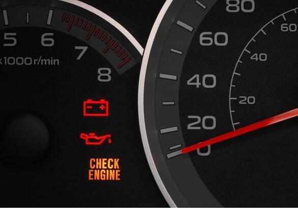 Close up on a cluster with the check engine warning light on indicating a car failure.