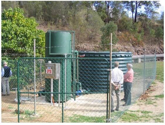 Figure 5.13 Scaled up Demonstration Pilot Plant at Hinze Dam showing the fluidisation column and tank for recycle batch tests.  microorganisms including Pedomicrobium in the raw water.  Figure 5.13 shows a photograph of the scaled up demonstration pilot plant situated at the base of the Hinze Dam. Details of the components are described in section 5.2.5 and in Figure 5.2. The scaled up pilot plant was operated intermittently from 12 August 2004 to 18 December 2004 in both batch and single pass continuous configuration. Initially the column was operated with a combination of surface and bottom (hypolimnium) water for a period of 2 weeks at less than a fluidising flow of 25-30 m h'. This was  considered to provide optimum conditions for establishment of a biofilm sourced only from natural  micronaraqaniame inclhidqing Pandnmirrnhis;m in the raw water 