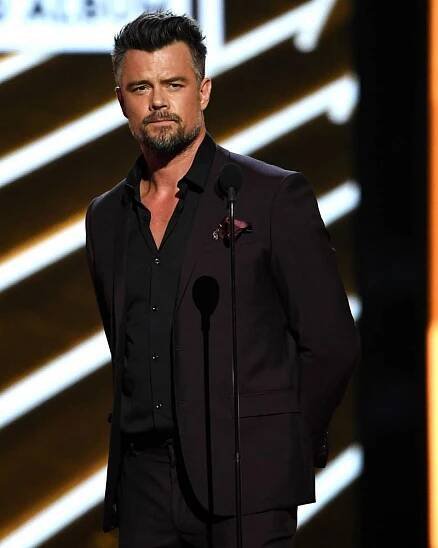 the actor is standing in front of a microphone