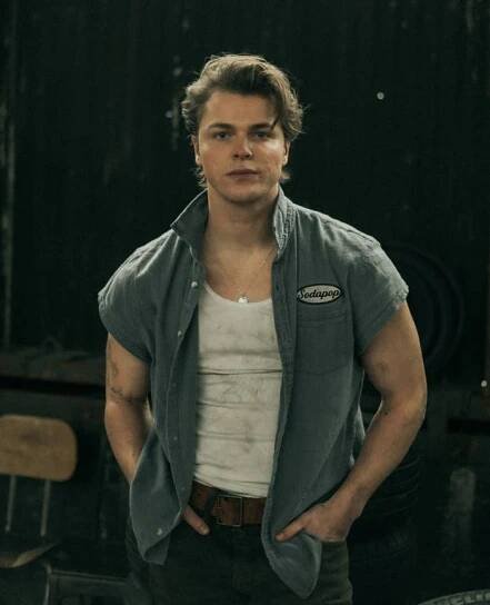 Jason Schmidt wearing casual sleeveless button-up shirt over a tank top, standing in an industrial setting