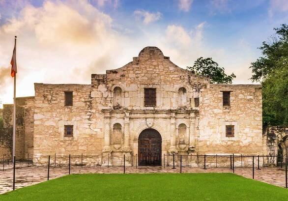 The Alamo in San Antonio, Texas underneath a blue, cloudy sunset sky.