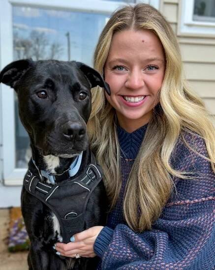 Leah Harvey posing with her dog 