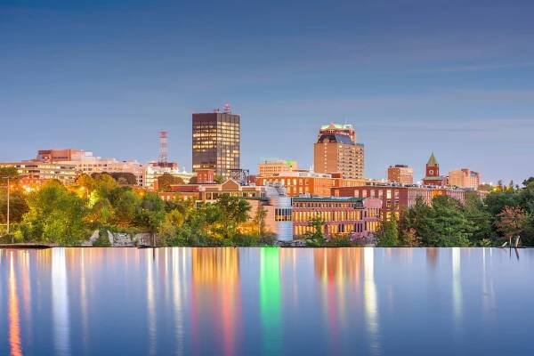 Manchester, New Hampshire, USA Skyline on the Merrimack River at dusk.