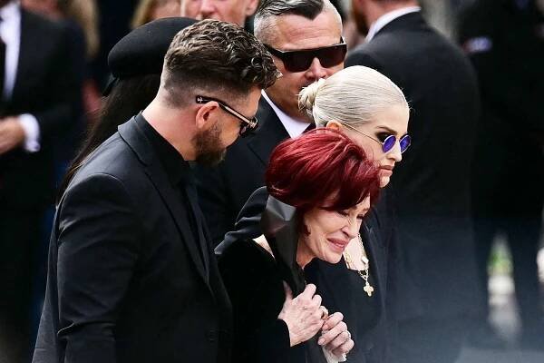 The family of Ozzy Osbourne, son Jack Osbourne (L), widow Sharon Osbourne (C), son Louis (back C), daughter Aimee (L obscured) and daughter Kelly Osbourne (R) arrive to lay flowers at the Black Sabbath Bridge bench on Broad Street during a funeral procession for Ozzy Osbourne, the late lead singer of Black Sabbath, in Birmingham, central England on July 30, 2025. Thousands are expected to line the streets in Ozzy Osbourne's UK hometown of Birmingham on Wednesday to honour the heavy metal hell-raiser Ozzy Osbourne as he is laid to rest. Osbourne, nicknamed the 