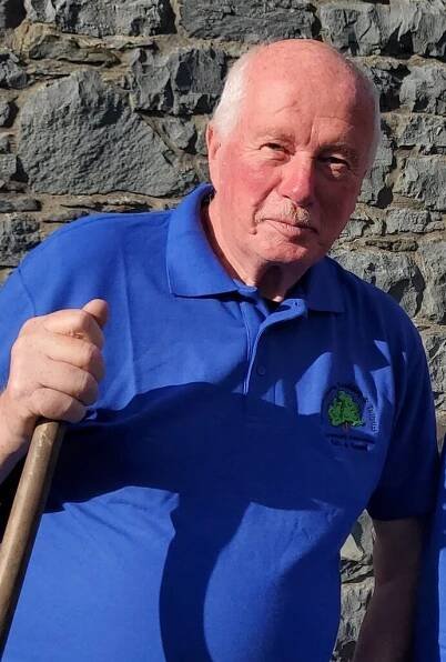 Photo of a man who volunteers for the LLTCA Safe and Sound Handyman Service. He is wearing branded clothing, blue with the LLTCA tree logo.