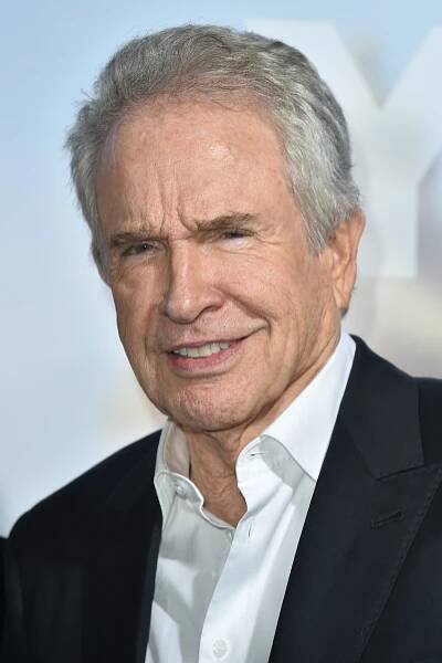 Warren Beatty in a black jacket and white shirt with the collar popping out of his jacket.