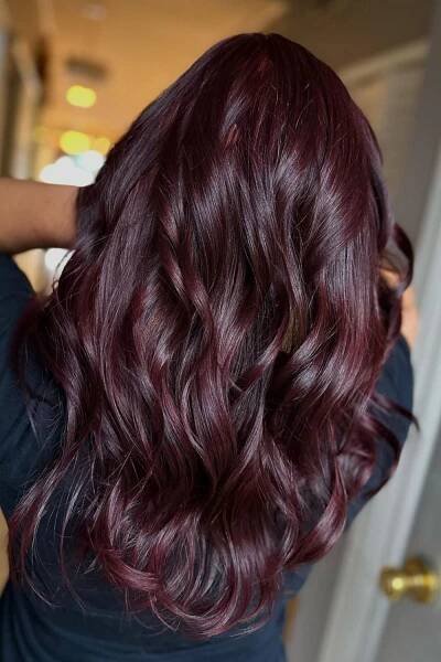 A woman with long wavy maroon hair.