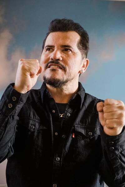 John Leguizamo with two fists poised and ready tor a fight.