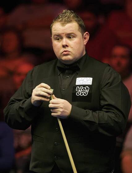 Stephen Lee chalking his cue during a snooker match.