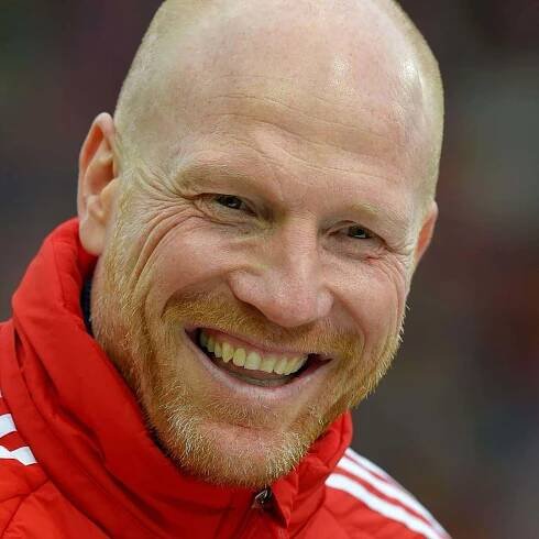 Matthias Sammer Adorning a Red Jacket with White Stripes Wallpaper