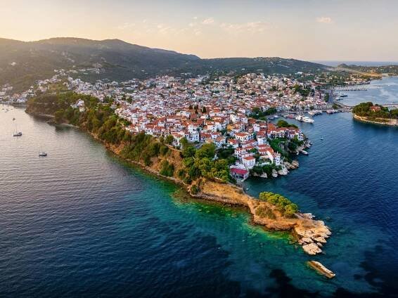Panoramatický výhled na starý přístav a město ostrova Skiathos, Sporades, Řecko, s poloostrovem Bourtzi a oblastí Plakes vpředu během západu slunce