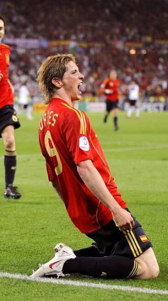 a soccer player sitting on the ground with his mouth open