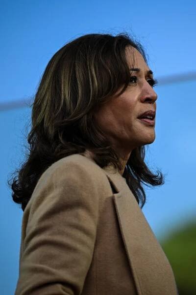 This is a photo, in profile, of Kamala Harris. She is wearing a light tan blazer.