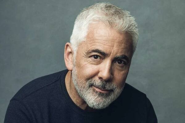 Adam Arkin smiling and posing.