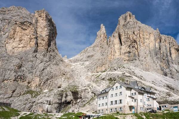 Rifugjo del Vajolet, a hut bulti below the Torri del Vajolet, which can be seen in the background.