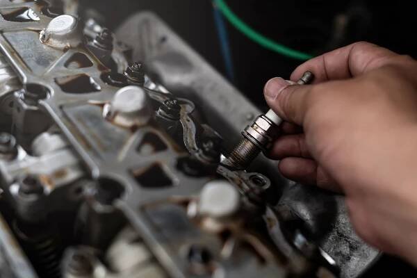 Old Car zapalovací svíčka v ruce Technik odstranit a změnit ve strojovně rozostření pozadí servisní koncept stock fotka
