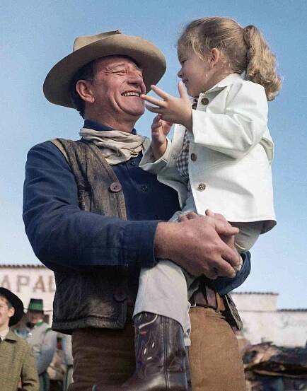 John Wayne holds his daughter, Aissa, on the set of "The Alamo".