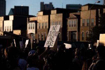 A sign that reads &quot;No Justice, No Peace&quot; is held up high during the march of police killings. No justice, No peace, has been used...