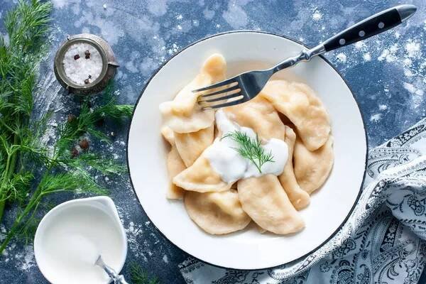 Dumplings with cheese and nettles in a traditional ceramic plate. Russian traditional cuisine — Stock Image
