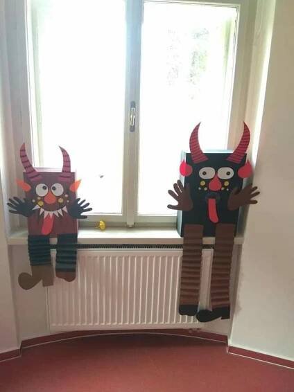 two paper cut out animals sitting on top of a window sill