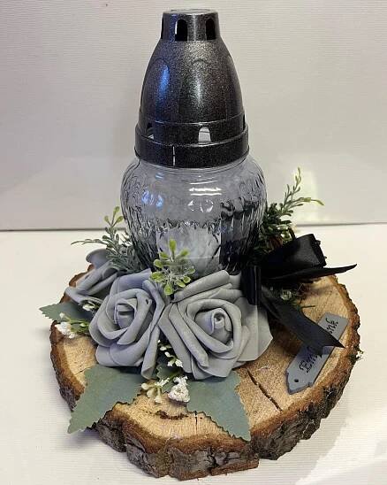 a vase with flowers on top of a piece of wood