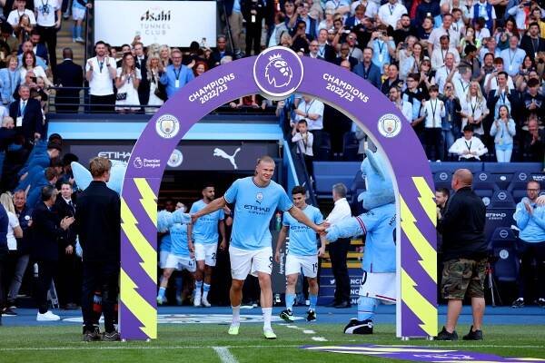 Erling Haaland of Manchester City shaking hands with the team mascots.