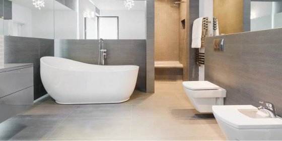moderní šedá koupelna s velkými zrcadly a bílou vanou
