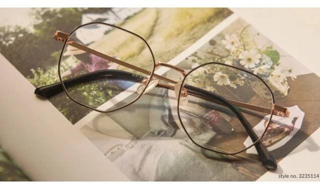 Gold-rimmed eyeglasses on a book, style no. 3235114.