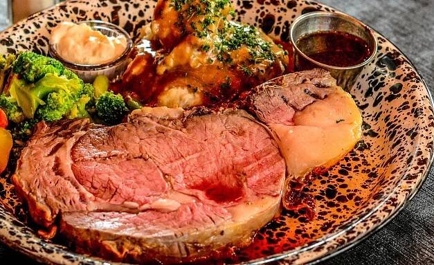 A plate of food with a piece of meat and potatoes.