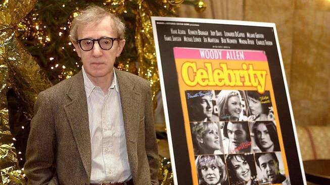 Woody Allen standing in front of the poster for the Movie "Celebrity."