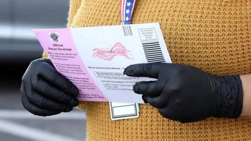 Pracovnice volebního oddělení drží hlasovací lístek v North Las Vegas, Nevada, 13. října 2020. (Ethan Miller / Getty Images)