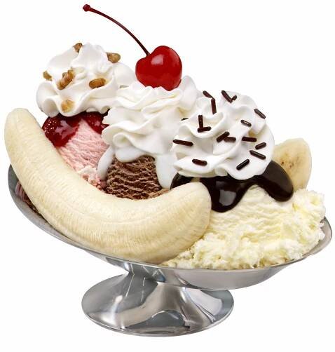 an ice cream sundae with banana split and cherries on top, in a silver dish