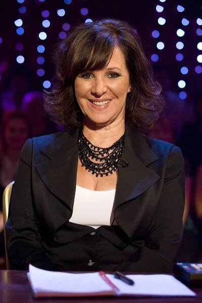 a woman wearing a black jacket has her arms crossed