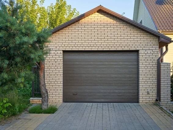 A brick garage with a brown roller door.