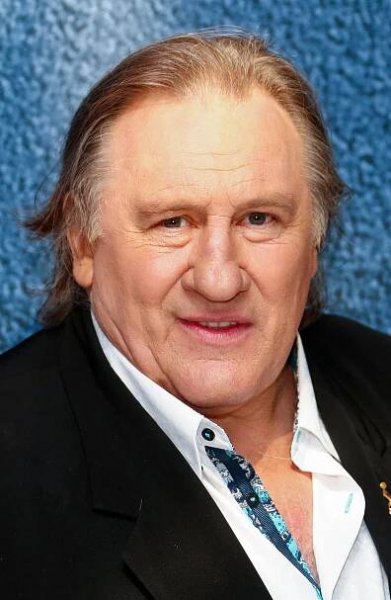 Gérard Depardieu in a white button-down shirt and black jacket.