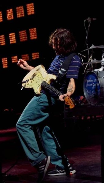 a man playing an electric guitar on stage