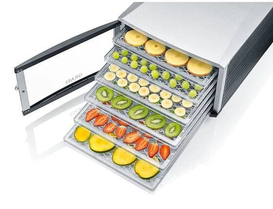 Food dehydrator with fruits and vegetables on the trays, silver color