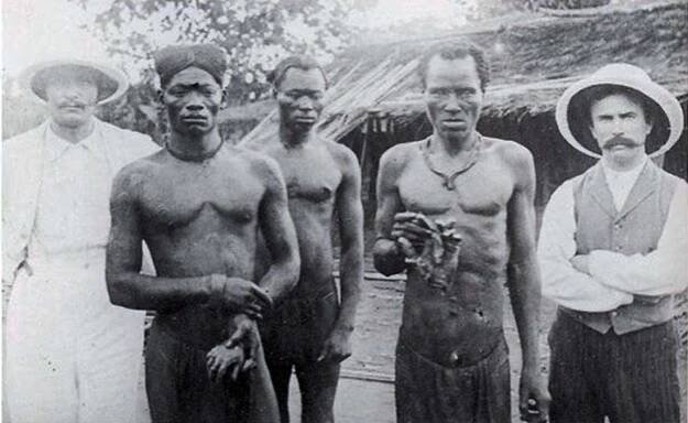 British missionaries with men holding hands severed from victims Bolenge and Lingomo by ABIR militiamen, 1904.