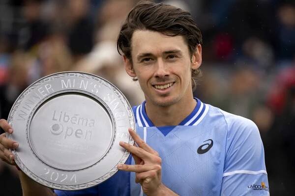 Alex de Minaur holding the Libema Open winner's trophy.