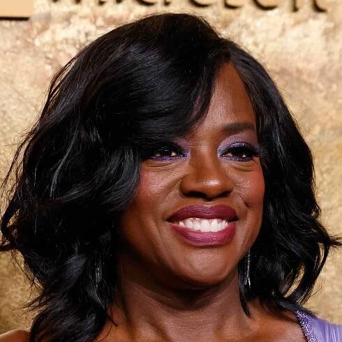 Viola Davis wearing purple shimmer eyeshadow and plum lipstick.