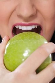 Žena kousání zelené jablko, zblízka — Stock obrázek