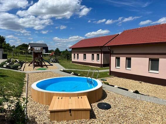 a swimming pool in a yard next to a building at Chaty Pálava in Dolní Věstonice