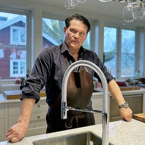 Per Morberg in front of the Estetic Duo sensor kitchen mixer with pull-off function.