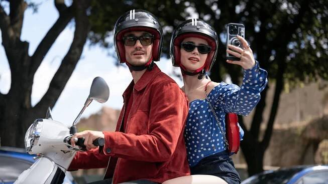 Image may contain Lily Collins Helmet Camera Electronics Accessories Glasses Adult Person Car and Transportation